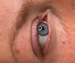 Nærbillede af blågråt øje før lash lift. Vipperne er lyse, lige og uden markant bue, hvilket giver et neutralt udtryk. Perfekt reference til at fremhæve effekten af vippebehandlingen efterfølgende.